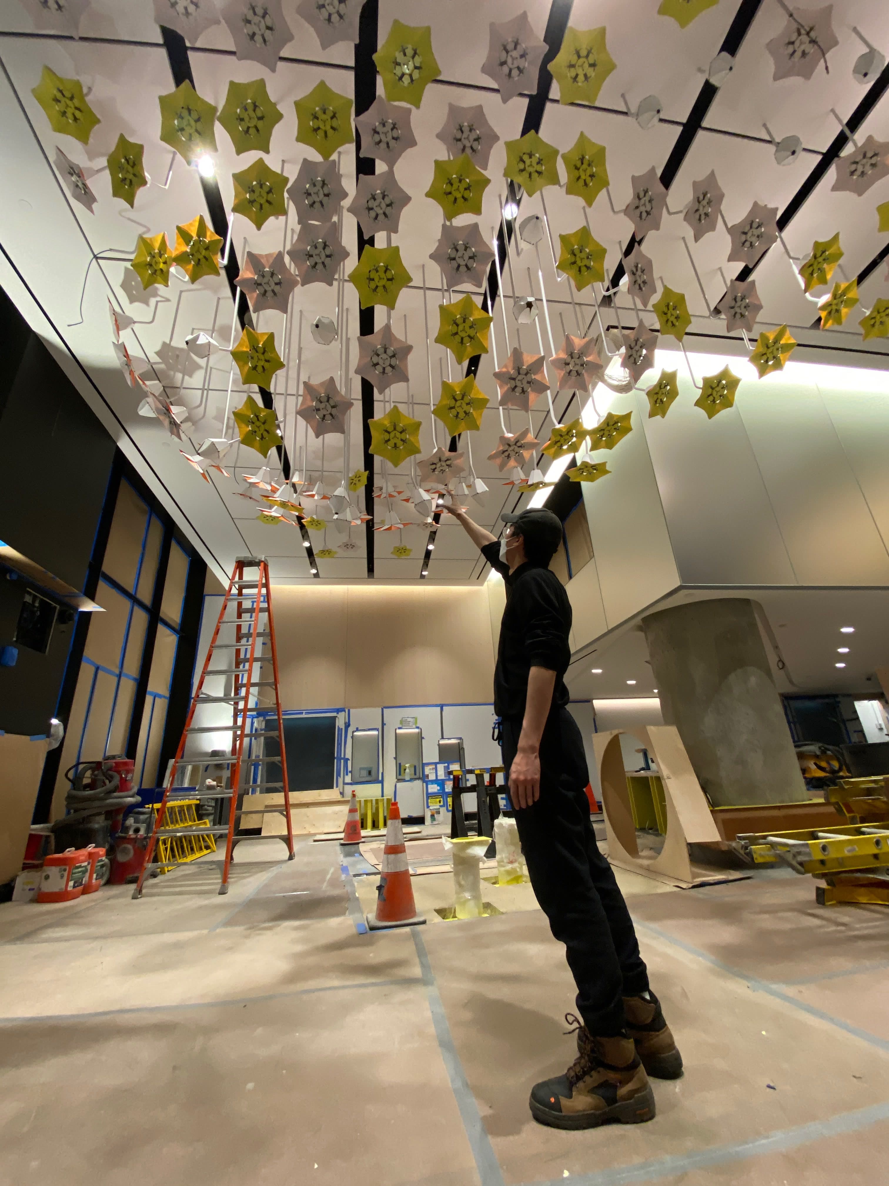 Standing under the suspended flower installation during build-out.
